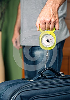 Man checking luggage weight with steelyard balance