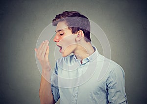 Man checking his breath with hand. photo