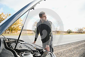 Man checking his broke down car
