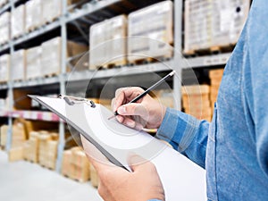 Man checking  list on clipboard in a warehouse