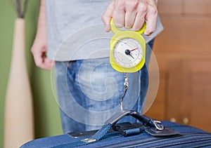 Man checking luggage weight with steelyard balance photo