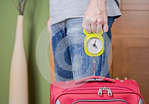 Man checking luggage weight with steelyard balance photo