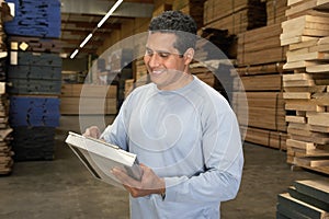 Man Checking Lumber In Warehouse