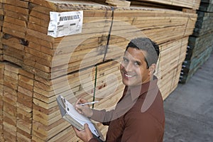 Man Checking Lumber In Warehouse photo