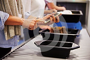 Man Checking Mobile Is Charged At Airport Security Check photo