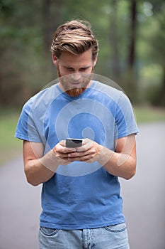 man checking online content walking in park