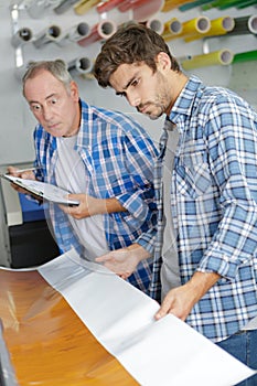 man checking paper et professional printing machine