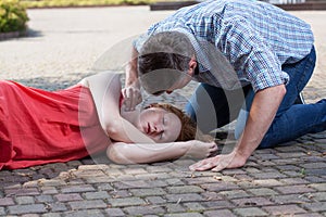 Man checking pulse of fainted girl