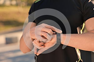 Man checking pulse after training outdoors, closeup. Space for text
