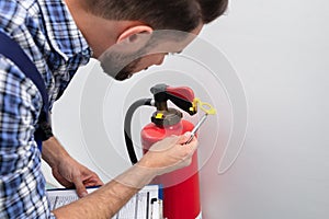 Man Checking Symbol On Fire Extinguisher