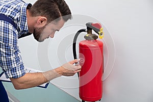 Man Checking Symbol On Fire Extinguisher