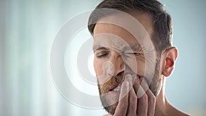 Man checking teeth in front of mirror, dental disease, gum infection, pulpitis