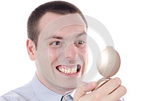 Man checking teeth in a mirror