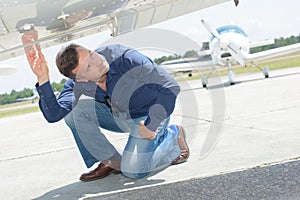 Man checking underside aircraft