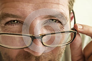 Man checking vision trying glasses at optometrist during optical examination testing spectacles correcting myopia struggling