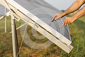 Man checking voltage in solar panels with multimeter