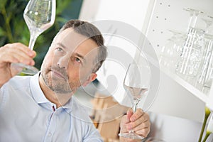 Man checking wineglass for cleanliness