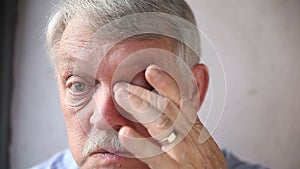 Man checks his bloodshot eyes