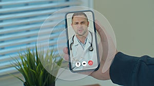 Man checks possible symptoms with professional physician, using online video chat. Young Man sick at home using