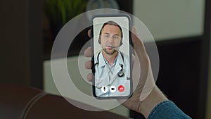 Man checks possible symptoms with professional physician, using online video chat. Young Man sick at home using