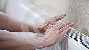 Man checks the temperature of the heating radiator