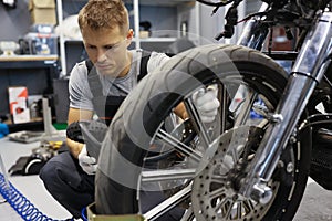 Man checks tire pressure on motorcycle in workshop