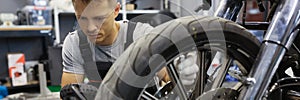 Man checks tire pressure on motorcycle in workshop