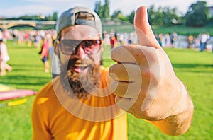 Man cheerful face shows thumb up. Man bearded in front of crowd riverside background. Top list summer festival must