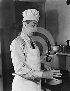 Man in chef hat and apron cooking