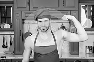 Man in chef hat, apron flex hand muscles with pepper