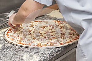 Man chef with raw pizza.