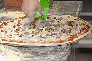 Man chef with raw pizza.