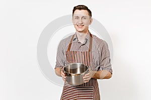 Man chef in striped brown apron holding silver stainless glossy aluminium empty stewpan, pan or pot isolated on white