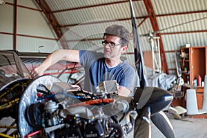 A man cheking avia oil in small aircraft