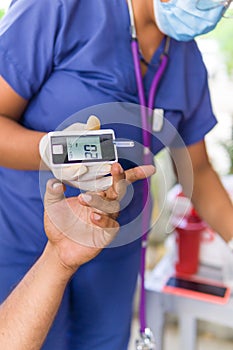 a man cheking suggar test with a glucometer photo