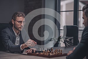 Man with chess piece looking at opponent