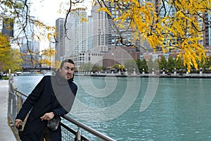 A man in chicago standing by the river
