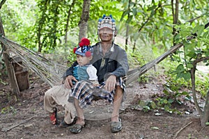 Man with child of Asia on hammock, Akha