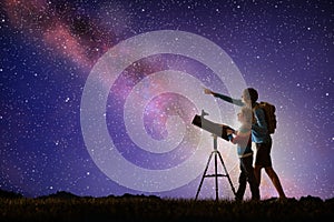 Man and child looking at stars through telescope