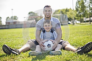 Man with child playing football on field