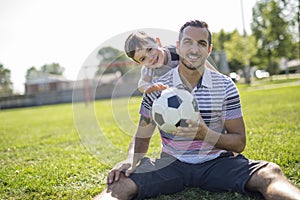 Man with child playing football on field