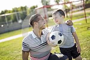 Man with child playing football on field