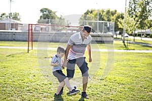 Man with child playing football on field