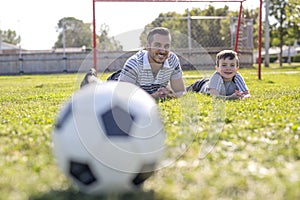 Man with child playing football on field