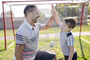 Man with child playing football on field