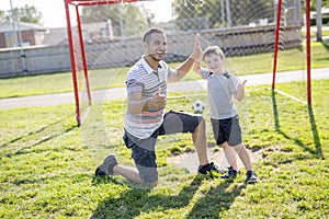 Man with child playing football on field