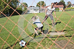 Man with child playing football on field