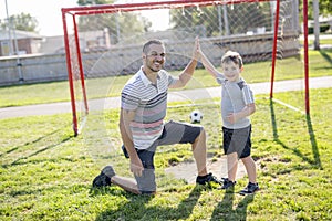 Man with child playing football on field