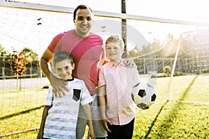 Man with child playing football outside on field