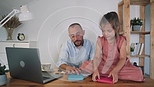 A man and a child are playing Poppit. A man and a girl compete by clicking on Poppit bubbles An anti-stress toy